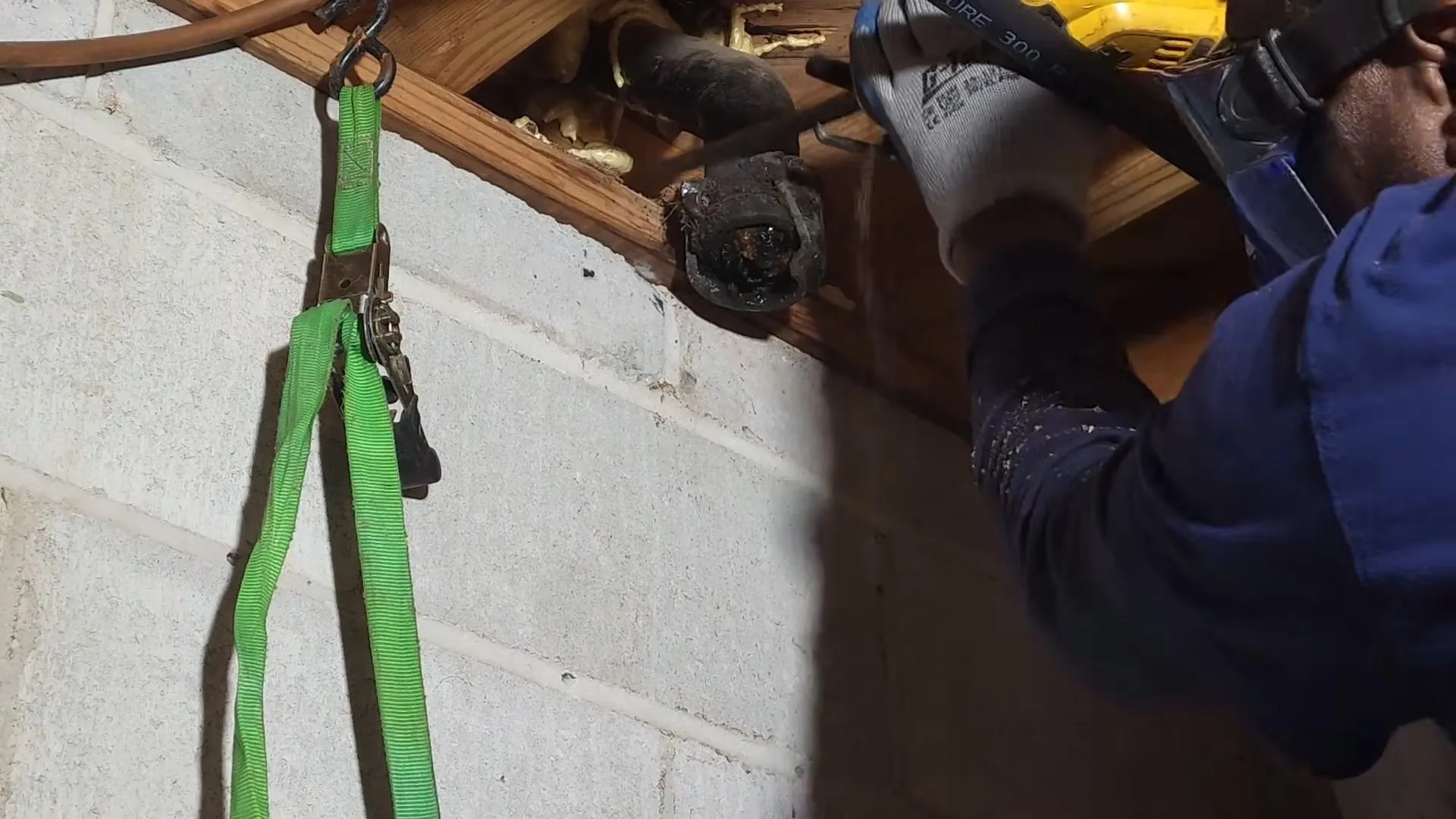 The plumber cutting exposed cast iron pipe pictured mid-repair on a Manassas-area emergency plumber job.