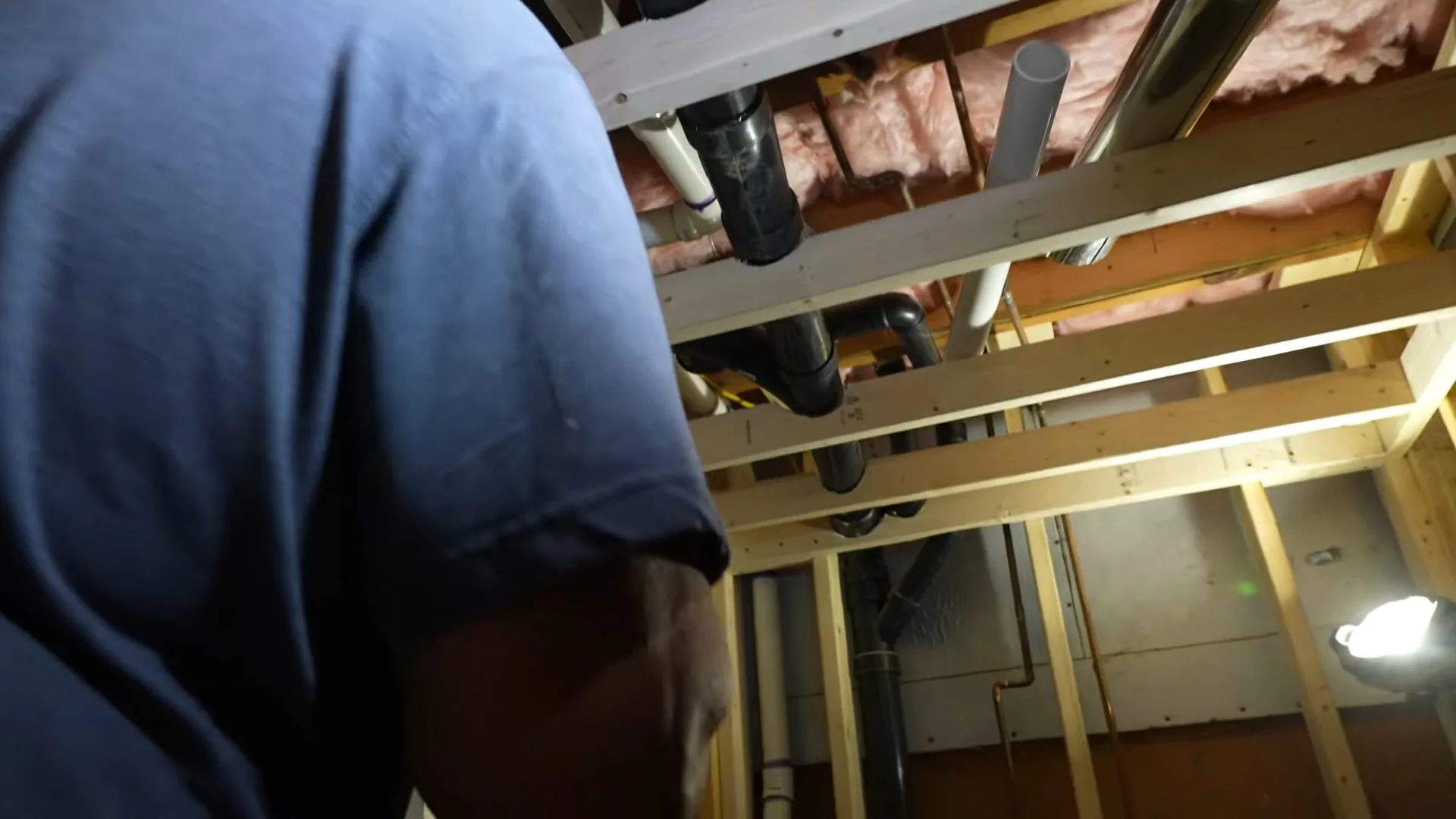 The plumber installing basement vent pipe photographed on site during emergency plumber work.