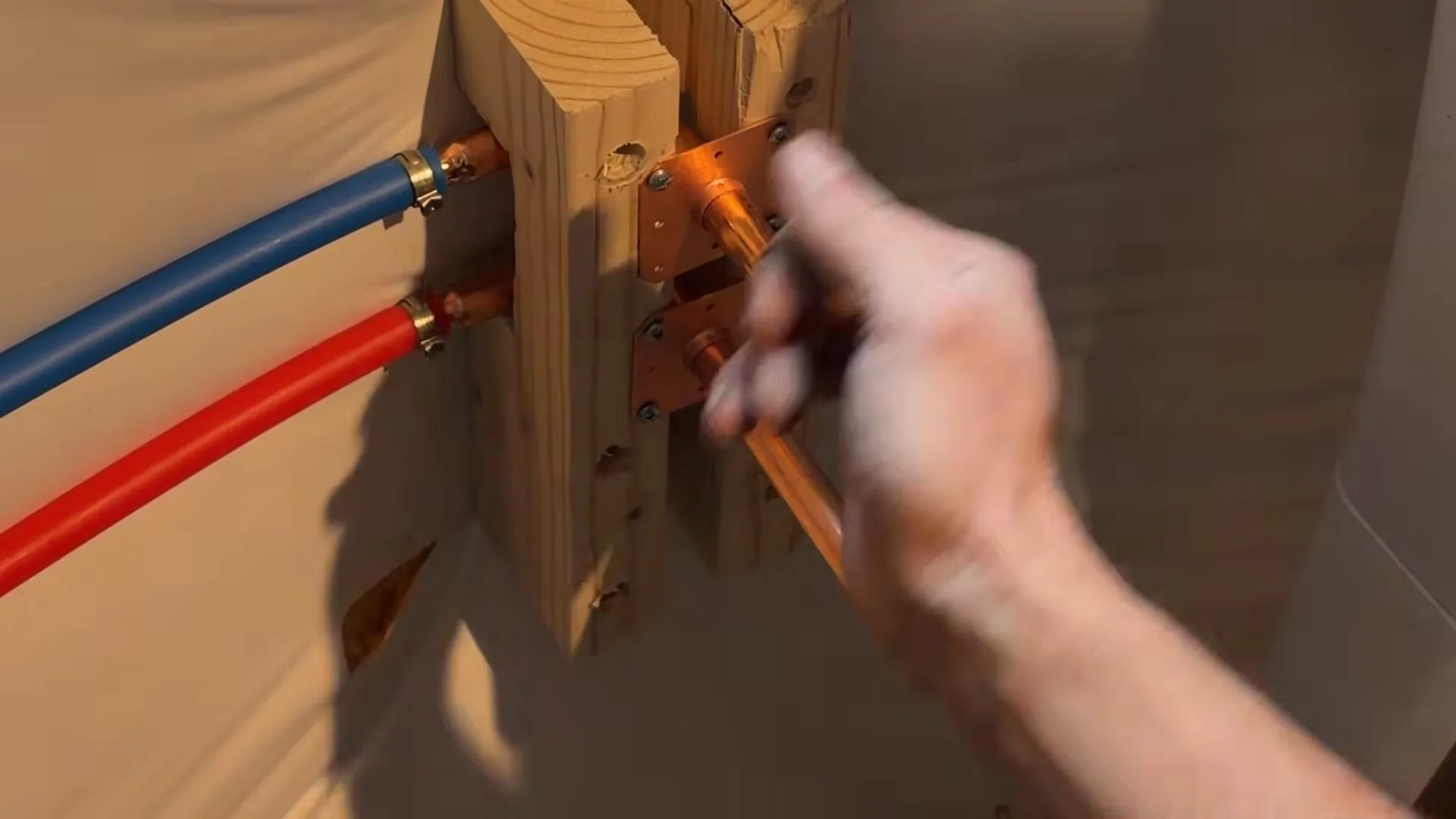A plumber working with the plumber measuring basement utility sink pipe as part of a emergency plumber call.
